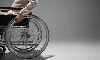 A man exits a room using a wheelchair