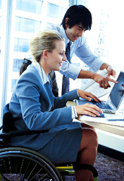 Two workers work at a computer
