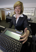An office worker demonstrates the text device she uses to communicate with customers who are deaf or hard of hearing.