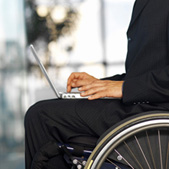 A person in a wheelchair uses a laptop