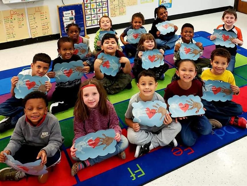 Photo of children holding up their artwork.