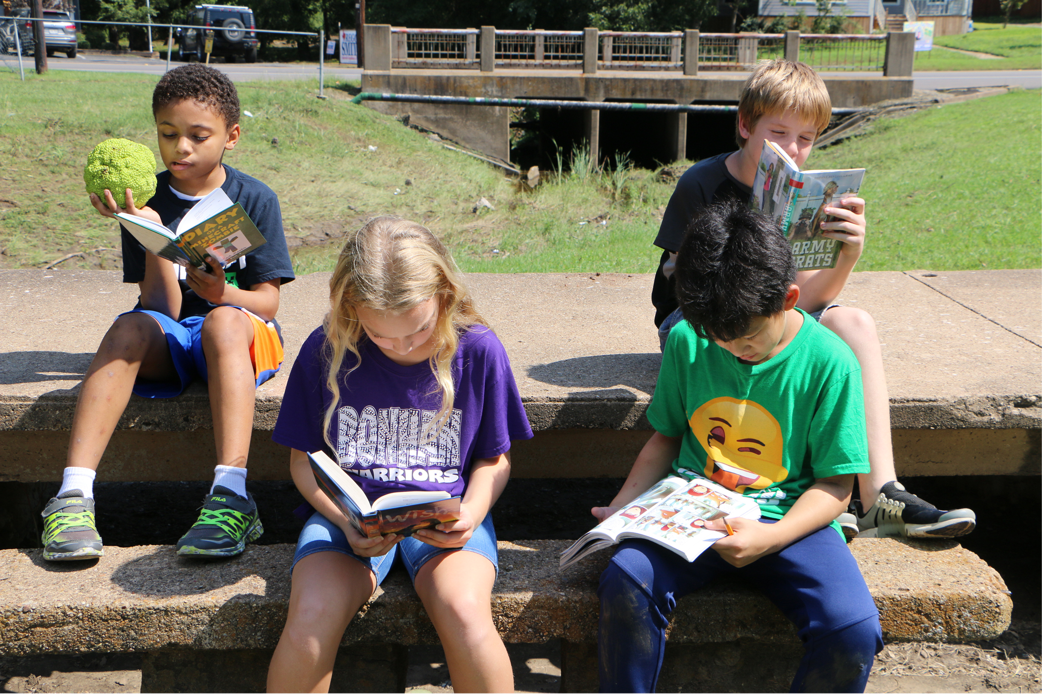 Four students reading outside